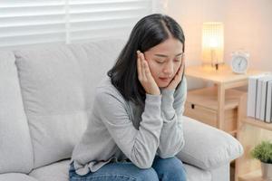 infeliz mujer asiática niña decepcionada, triste por el problema solo en casa, se siente sola, estresada, sufre de mala relación, ruptura, divorcio, mujer confundida, depresión salud mental, soledad foto