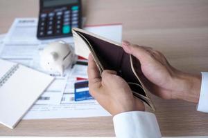 Hands open the empty purse after calculating the cost from the credit card and bill. debt concept photo