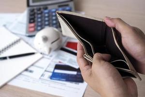 Hands open the empty purse after calculating the cost from the credit card and bill. debt concept photo