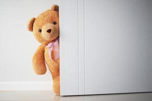 Teddy bear with brown hair behind open door. Background for kids play Teddy bear photo