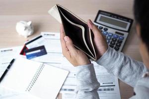 Hands open the empty purse after calculating the cost from the credit card and bill. debt concept photo