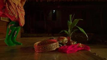 Asian woman sitting in front of the offerings with an orange dress before the ritual begins inside the village video