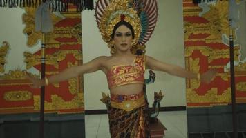 een balinees vrouw aan het doen een traditioneel balinees dans binnen de tempel met een oranje kostuum video