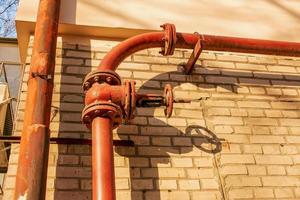 Rusty old gas tap on the background of the wall of the house. photo