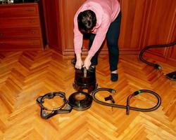 A middle-aged woman collects a vacuum cleaner for house cleaning. photo