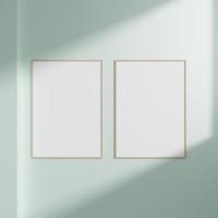 Minimal empty frame picture mockup hanging on white wall background with window light and shadow photo