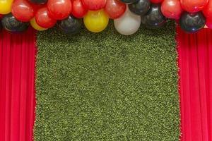 Beautiful green wall grass panel with colorful balloons photo