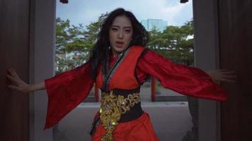 belles personnes chinoises dansant avec énergie tout en portant un cheongsam devant une porte chinoise video