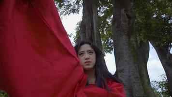 A Chinese Woman performing martial arts while wearing are Chinese shirt in the garden video