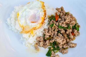 holy basil minced pork, Stir fried Thai basil with minced pork and a fried egg on white plate photo