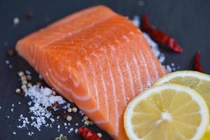 Fresh salmon fillet on dark background photo
