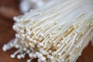 Enoki mushroom or Golden Needle Mushroom on wooden background photo