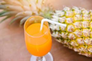 Summer orange and pineapple juice glass and fresh pineapple tropical fruits photo