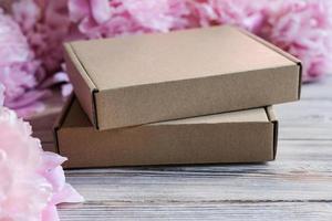 Brown cardboard boxes and peony flowers. Package box for branding. Mock up gift boxes photo