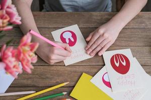 niño haciendo tarjeta de felicitación de pascua. materiales para la creatividad artística en la mesa de los niños, pintura infantil. actividad de manualidades de papel en jardín de infantes o aprendizaje en casa foto