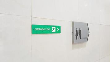 Restroom sign or toilet sign and emergency exit door sign on the wall photo
