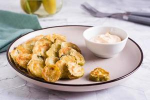 Fried pickles and sauce on a plate. American snack. photo