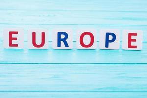Word Europe on blue wooden background. Copy space and selective focus photo