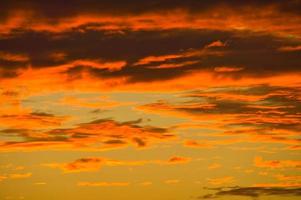 Background image with clouds in extreme colors of a sunset. The sky seems to burn photo