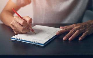 la mano del hombre es escribir una nota en un calendario foto