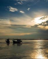 Vertical image view atmosphere sea decreasing with time day. Able to see two fishing boats moored And long stretch of sand on beach In evening at sunset Shouting in twilight that looks sky beautiful photo