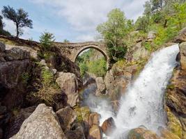 ponte da misarela o puente de mizarela en montalegre, portugal con una gran cascada al lado durante un día soleado. viajes rurales y vacaciones en la naturaleza. foto