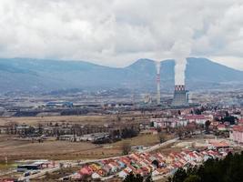 Thermal power station expelling pollutants to the air. City with poor air quality due to thermal power plant. Burning fossil fuel. Toxic air for people in the cities. photo