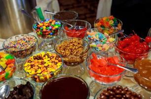 Candies in glass jars in candy shop photo