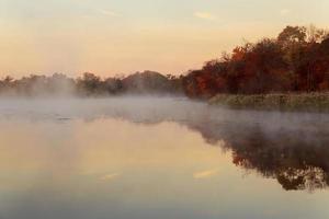 Fog over river in forest in the autumn photo