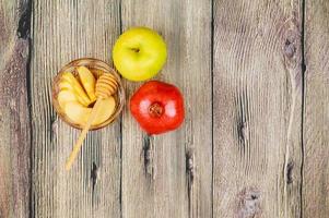 rosh hashaná jewesh vacaciones miel, manzana y granada sobre mesa de madera. símbolos tradicionales. foto