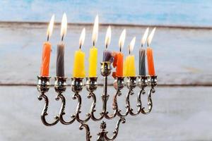 Hanukkah menorah with candles and silver dreidel. photo