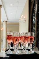 Festive champagne flutes filled with sparkling wine and floating strawberries romantic twinkling party lights photo