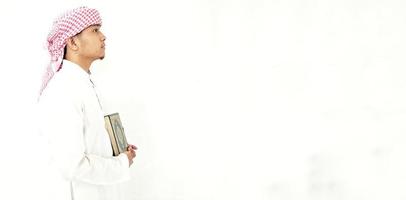 hombre sosteniendo y leyendo el corán. fondo islámico foto