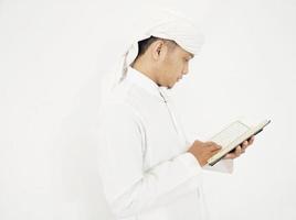 hombre sosteniendo y leyendo el corán. fondo islámico foto