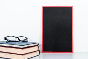 Chalkboard mock up frame and old books with eyeglasses photo