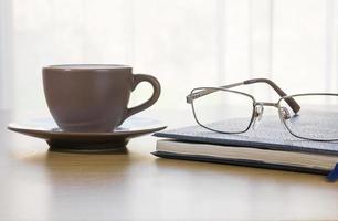 Glasses and book on the desk photo