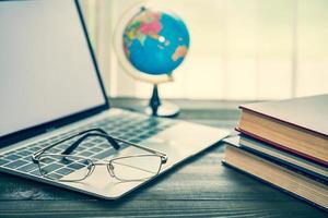 Eye glasses and book beside the window photo