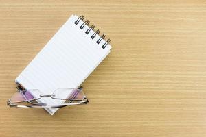 Eyeglasses and Notepad with blank page photo