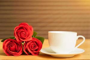 Red rose and coffee cup on wood photo