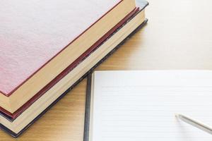 escritura de la pluma en la página en blanco abierta del cuaderno foto