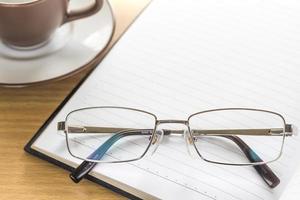 Eyeglasses put on note pad open blank page photo