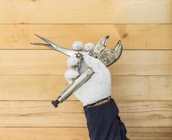 Hand in glove holding Adjustable wrench photo