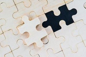 wooden jigsaw puzzle pieces on black background photo