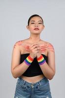 Portrait young asian woman in concept LGBQ with wristband on white background photo