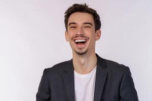 Portrait of happy cheerful young man laughing and looking straight at camera isolated over white background photo