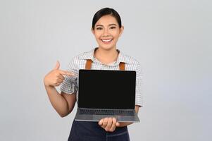 Portrait of young asian woman in waitress uniform pose with laptop computer photo