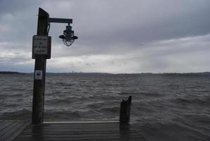 poste de luz al final del muelle bajo las nubes foto