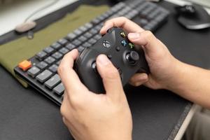 samutprakarn tailandia 23 de enero de 2023 mano que sostiene el gamepad inalámbrico para xbox one, una consola de videojuegos doméstica producida por microsoft. controlador de juego xbox negro. foto