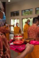 Bandung, Indonesia, 2020 - A Group of monks with orange and red robes praying together at the altar photo