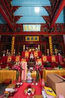 Bandung, Indonesia, 2020 - The monks in orange rob standing in order while praying to the god at the altar inside the Buddha temple photo